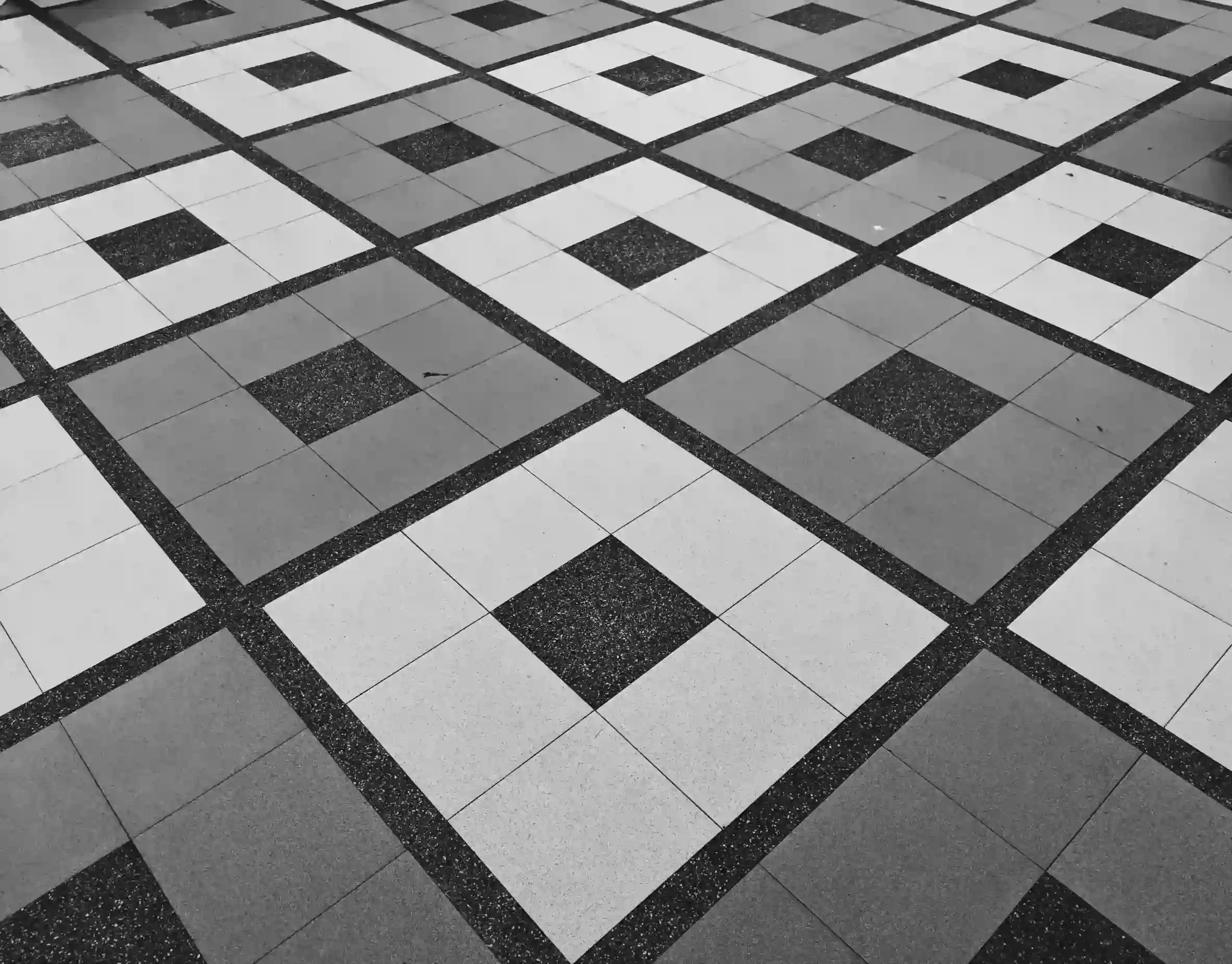 Black and white geometric square terrazzo floor tile pattern in a commercial space