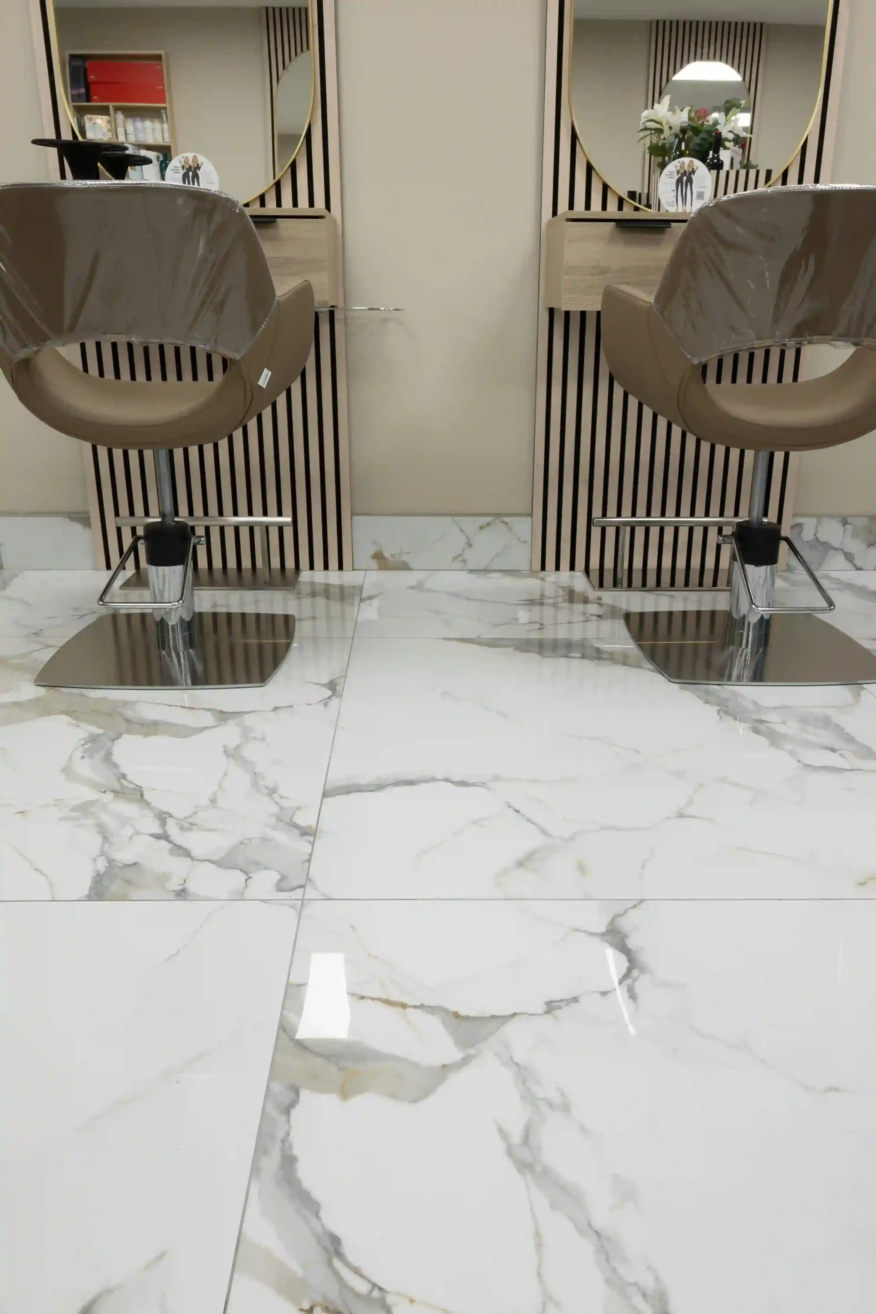 Polished Calacatta marble-look porcelain tile on a hair salon floor with styling chairs